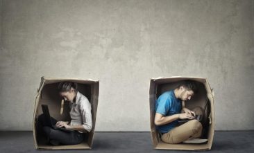 Man and woman in two individual boxes using laptops
