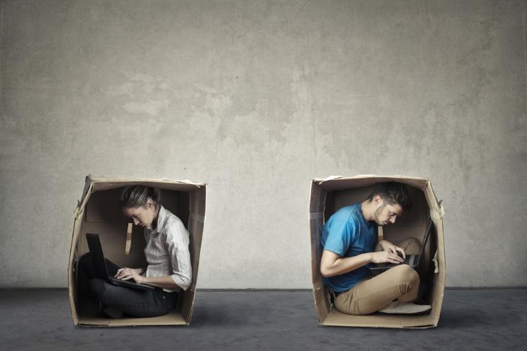Man and woman in two individual boxes using laptops