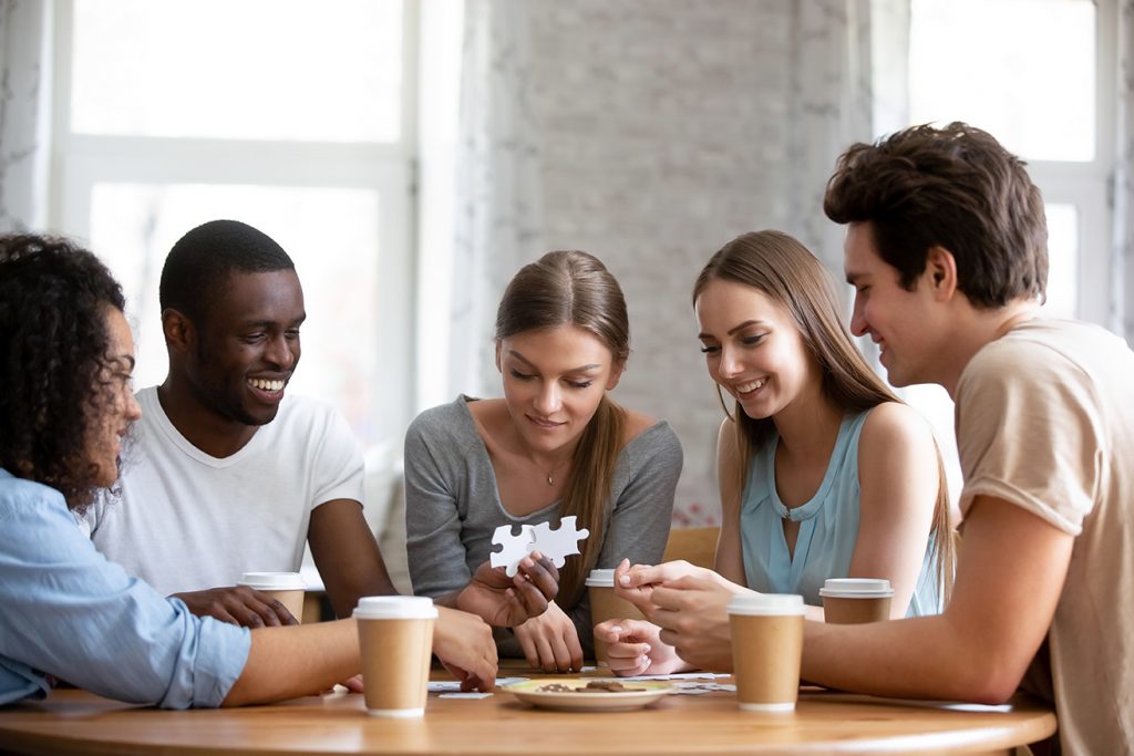 Group of people solving puzzle at table