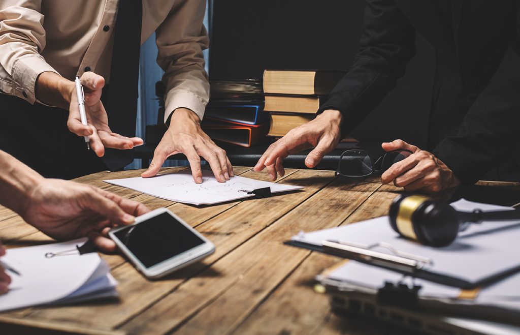 Legal team looking at documents on a wood table