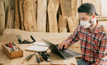 Contractor researching SEO on laptop in shop